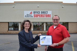Standing in front of Office Direct in Stevens Point, CAP Services’ Laura West presents business owner Cole Corrigan with a certificate recognizing the business as the winner of CAP’s first Business Expansion Contest.
